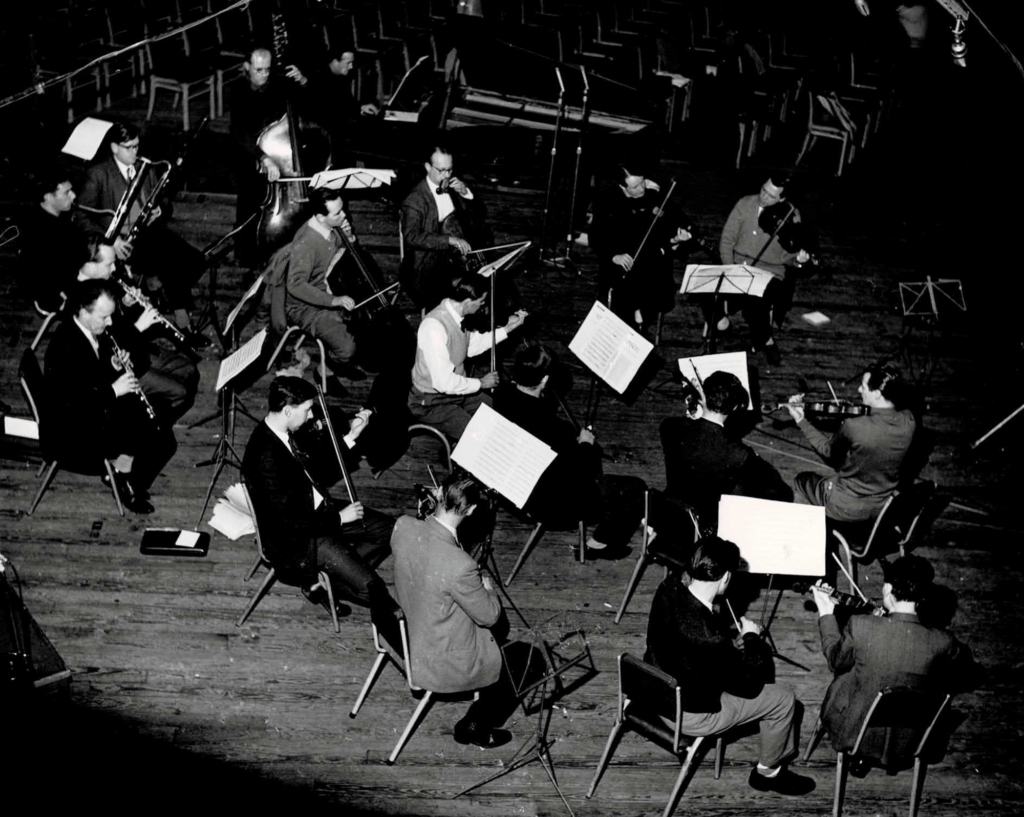 A black-and-white aerial shot of the Academy of St Martin’s in action, recording Handel in Kingsway Hall for Argo in 1964; Neville Marriner leading (centre right).
