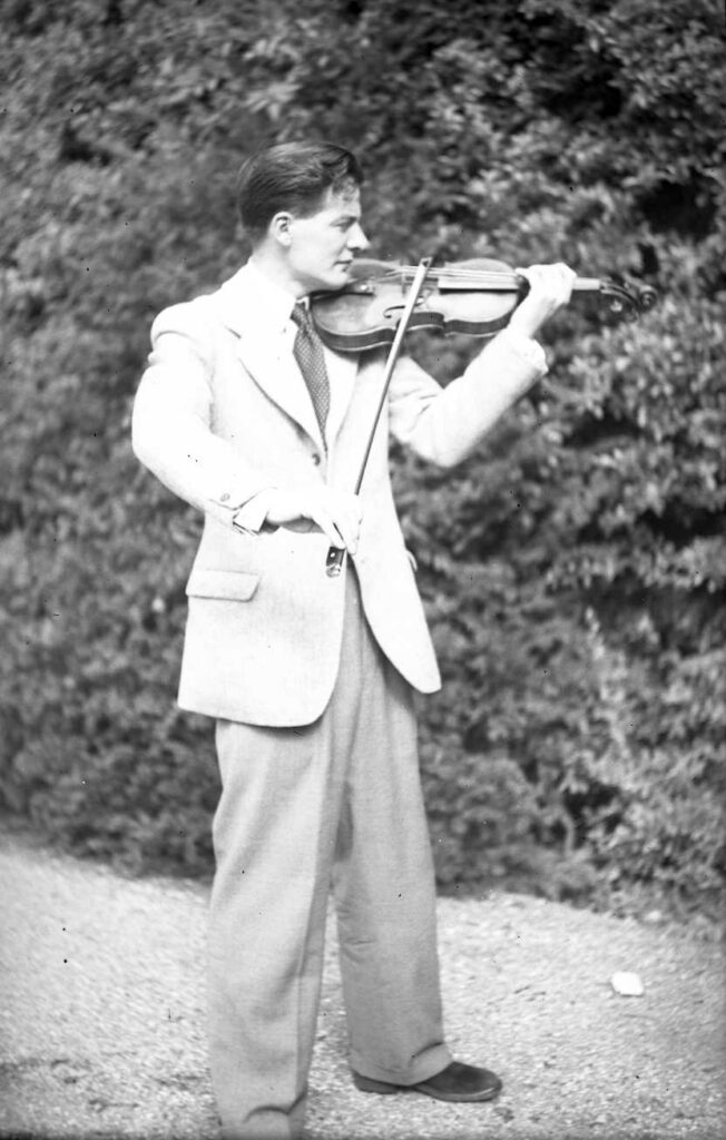 Marriner in his early thirties, posed with violin in front of a hedge at Dartington Summer School, Devon. In later years his Academy of St Martin’s would attend for one or two weeks to play and teach there.