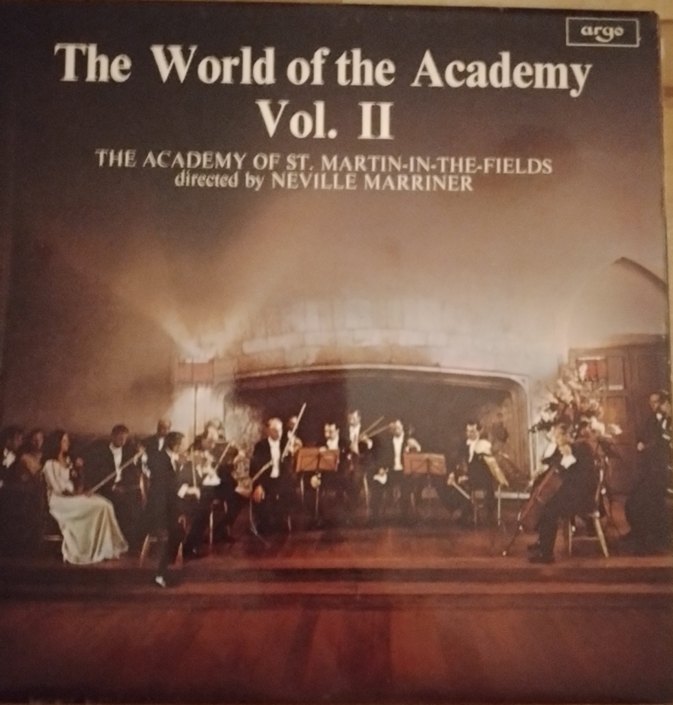 This colour photo, used on the LP sleeve for Argo’s ‘The World of the Academy, volume 2’ shows the 16-strong band in concert dress on the platform of the Great Hall at Dartington in 1970.
